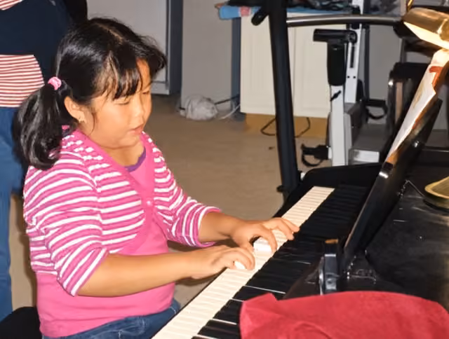 Childhood photograph of Kathleen playing the piano